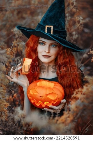 Fantasy red-haired witch in a black hat with a pumpkin in her hands. Red-haired witch with a Halloween pumpkin. Halloween. Jack o' Lanterns. October 31