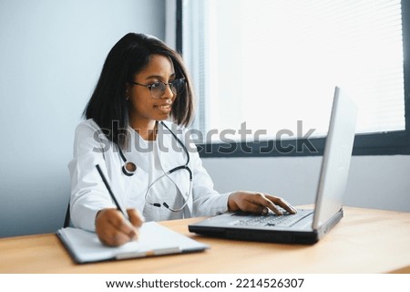 healthcare, medical and technology concept - african female doctor with laptop. Royalty-Free Stock Photo #2214526307
