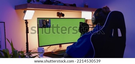 GREEN SCREEN CHORMA KEY Caucasian teen girl gamer streamer putting on headphones, playing online games and streaming from home