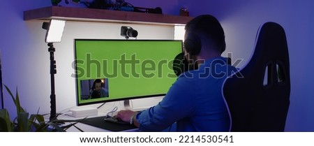 GREEN SCREEN CHORMA KEY Hispanic male playing online games and streaming from home