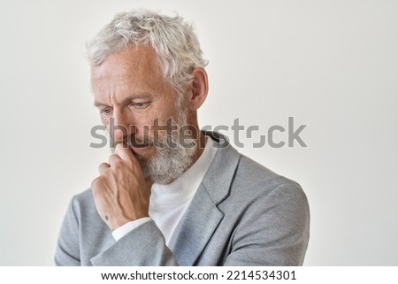 Thoughtful sad older business man investor, frustrated depressed middle aged senior professional businessman thinking of bankruptcy or making difficult decision standing isolated on white wall. Royalty-Free Stock Photo #2214534301