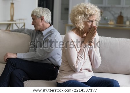Silent older wife and husband sit apart in couch feel dissatisfied with relations, having problems in marriage, think about break up, divorce. Crisis in relationships, abuse, marriage split, betrayal Royalty-Free Stock Photo #2214537197