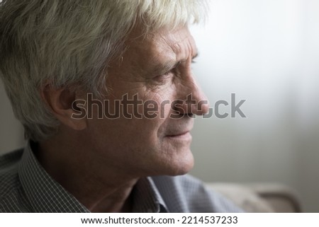 Close up profile view face of sad senior man staring into distance looking pensive, deep in thoughts and life troubles. Baby boomer generation person portrait, loneliness in older age, nostalgia Royalty-Free Stock Photo #2214537233