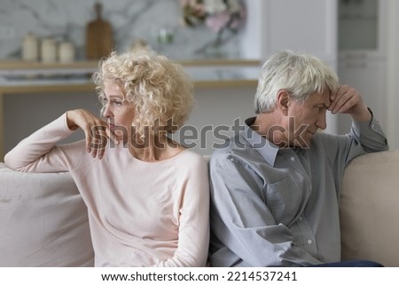 Unsuccessful relationships, failed marriage, relations break up, misunderstanding. Silent sad older married couple sit on sofa separately ponder over problems feel dissatisfied, thinking about divorce Royalty-Free Stock Photo #2214537241