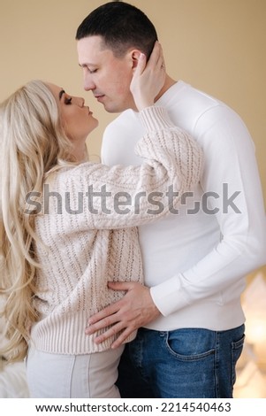 Gorgeous woman with her husband posing to photographer at home. Christmas mood