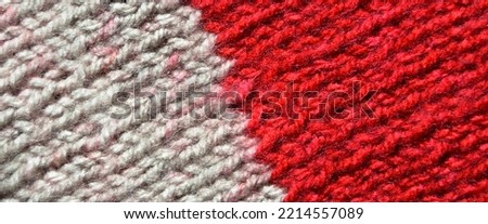 Pattern fabric made of wool. Handmade knitted fabric red and white wool background texture