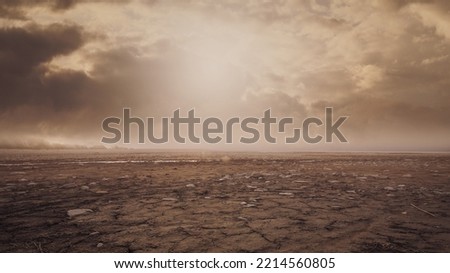 Dry barren land with cloudy polluted sky, climate change and desertification concept Royalty-Free Stock Photo #2214560805