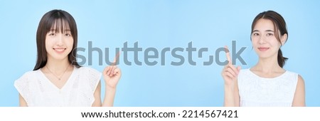 Asian young women posing with their index fingers up