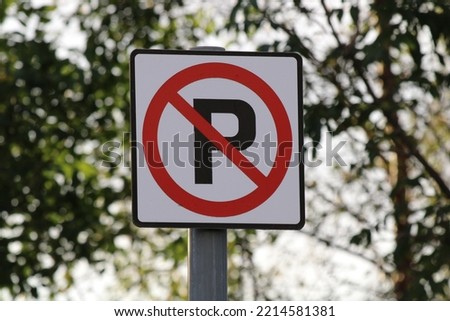 Prohibited Parking Road Sign With a Red Circle and Line Over a Letter P on Bokeh Green Foliage Background