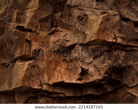 Dark yellow orange red brown rock texture. Rough mountain surface. Close-up. Stone granite background for design. Natural. Wallpaper. Solid, durable. 3d shape.