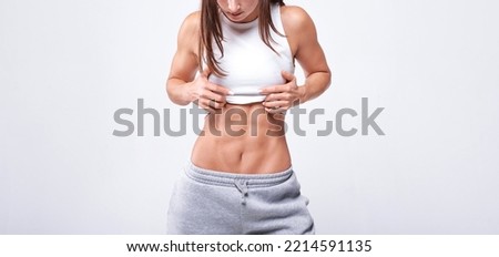 No name portrait. Young white fitness woman wearing sportswear standing over white wall background. Fitness concept. Mixed media Royalty-Free Stock Photo #2214591135