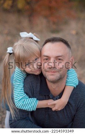 Daughter with dad. Family. The blue-eyed girl hugs her dad.