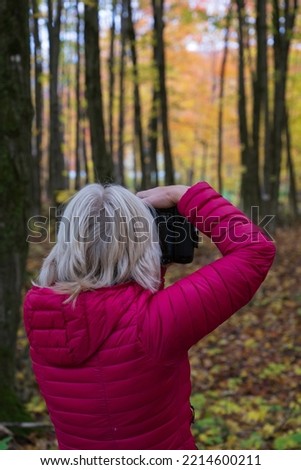 A woman taking pictures of the Quebec fall colors