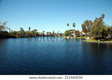 Private Lake with homes and boats in Lake Forest California. Lake Forest has many Private Lakes with limited access to the general public, making it an ideal and serene location to live life.  Royalty-Free Stock Photo #221460034