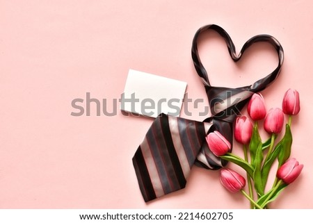 Men's necktie with tulips and blank card on pink background. Copy space. Flat lay, top view. Fathers day, Boss day, mens day, valentine's day for holiday banner. Template for Greeting card. 