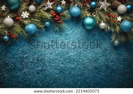 Christmas background in turquoise blue, with textured copy-space and an arch-shaped border composed of fir branches, baubles, stars and holly