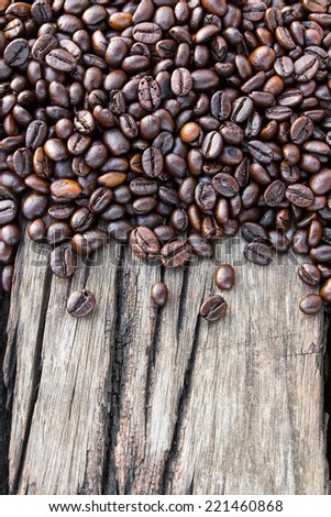 Background above a pile of coffee beans scattered on old wood cracked.