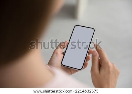 Unknown woman holds mart phone with white blank mock up screen view, close up. Female using web site, makes call, order goods, enjoy remote comfort services, advertising new application or software Royalty-Free Stock Photo #2214632573