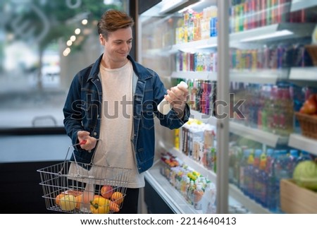 An European man but a bottle of milk from refrigerator cold in convenience store for drink at home Royalty-Free Stock Photo #2214640413