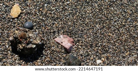 wavy and foamy sea, beach, reflected sunlight, colorful sand, colorful pebbles, sea stoneS on the seashore