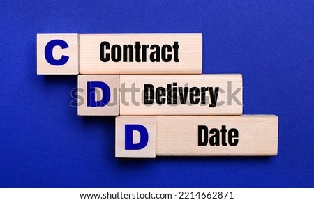 On a bright blue background, light wooden blocks and cubes with the text CDD Contract Delivery Date