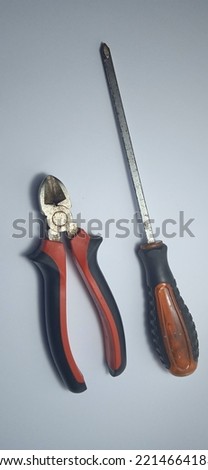 cutting pliers and flower screwdriver in black red on a white background