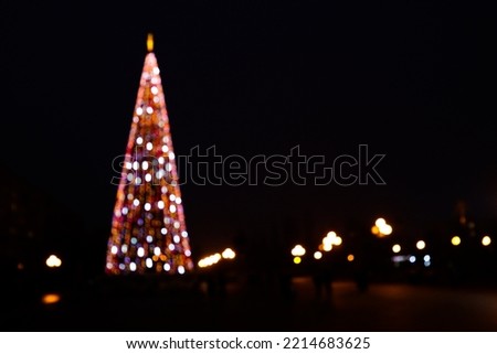 Abstract Christmas defocus background with tree silhouette with bright festive lights.