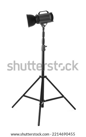 Studio flash light on tripod against white background. Professional photographer's equipment Royalty-Free Stock Photo #2214690455
