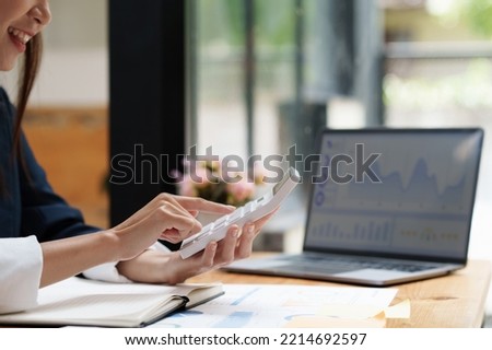 Asian Business woman writing saving account balance with working at home, account and saving concept