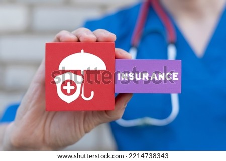 Doctor holding styrofoam colorful blocks with icon of umbrella, shield and word of insurance. Medicine health care assurance treatment. Medical Insurance Concept.