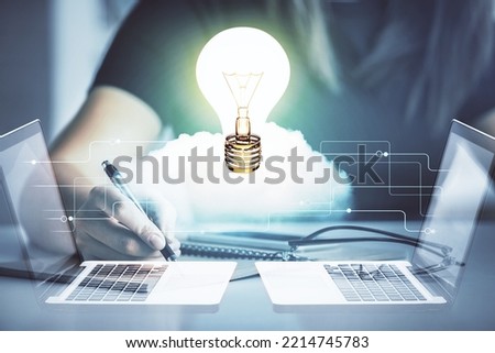 Bulb hologram over hands taking notes background. Concept of idea. Double exposure
