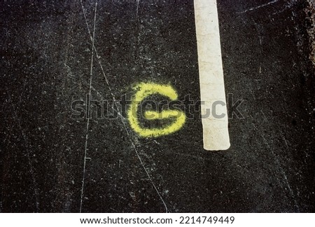 Yellow «G» taged on the road