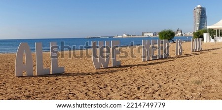 Panoramic style All We Need is Love sign on a Mediterranean beach