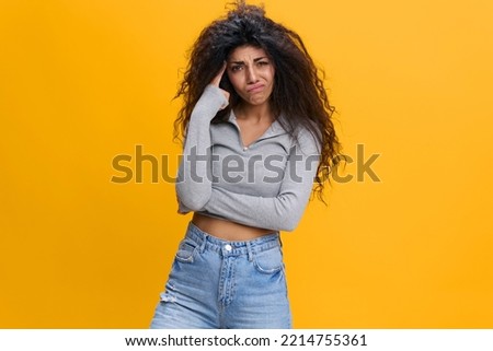 Angry displeased upset young curly black women 20s wearing casual shirts clothes stand isolated on plain pastel orange background studio portrait. People emotions concept