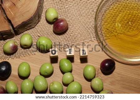 Olives and Olive Oil on wooden background
