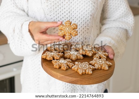 Christmas shortbread snowflakes. Women's hands hold traditional New Year's gingerbread