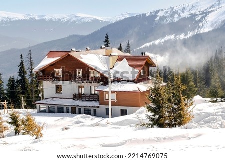 Green high spruce pine trees and vintage old retro wooden village rural house covered in snow in winter forest in mountains,nature. Calm countryside. Home residence in coniferous trees.Eco concept. Royalty-Free Stock Photo #2214769075