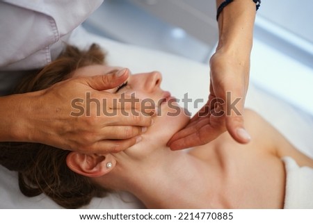 Face massage. Young pretty woman having face massage in the salon. High quality photo