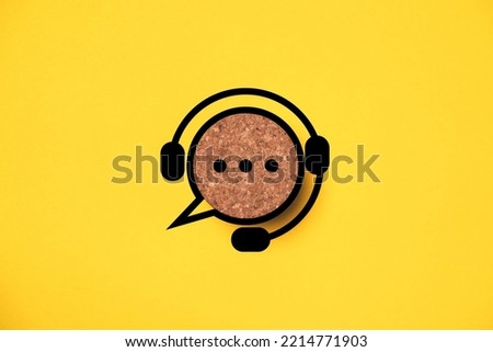Headphone logo with speech bubble message icon on round wooden for support and customer service concept. Royalty-Free Stock Photo #2214771903