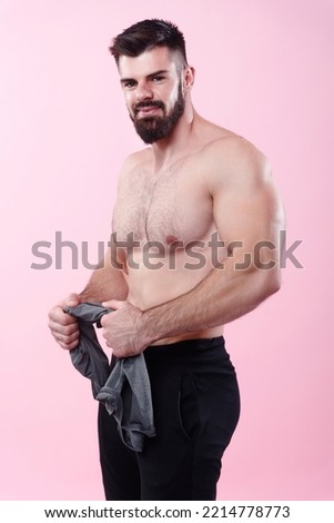 Happy shirtless bodybuilder standing straight, posing with a smile on a pink background Royalty-Free Stock Photo #2214778773
