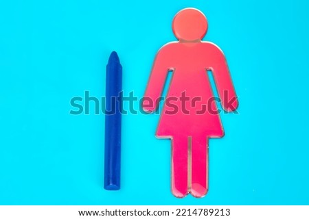 A blue wax crayon laid flat beside a girl character symbol
