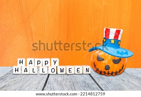 Happy Halloween sign with halloween pumpkin wearing bozo hat with space on orange texture background, Halloween card background idea