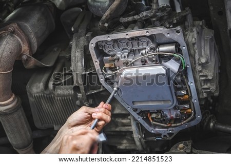Auto mechanic installing an automatic transmission filter.  Royalty-Free Stock Photo #2214851523