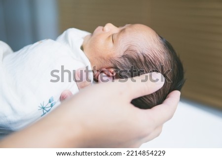 close up picture of Newborn baby on hand father's for shower. 