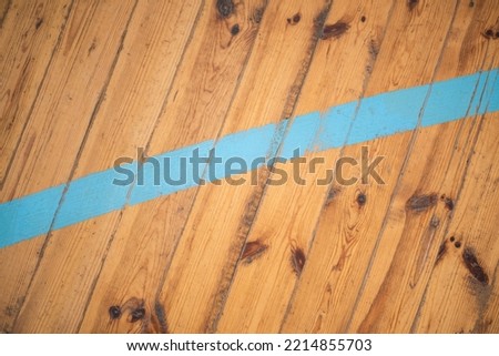 Old wooden floor of the gym. Orange blue sports background.