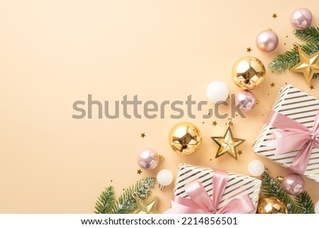 New Year atmosphere concept. Top view photo of present boxes with ribbon bows gold and pink baubles star ornaments fir branches in snow and confetti on isolated light beige background with blank space