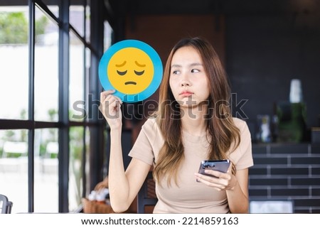 Customer experience review and feedback satisfaction service concept. Customer woman holding unhappy face emoji for giving good feedback rating