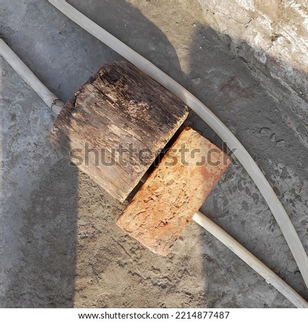 A piece of brick and wood is placed on the ground. and stock image 