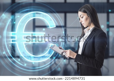 businesswoman using tablet with creative glowing euro hologram on blurry office interior backround. Futuristic hi-tech digital money and electronic economy of the future concept. 