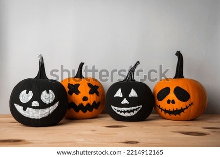 Halloween celebration. Pumpkins with spooky drawn faces on wooden table, space for text